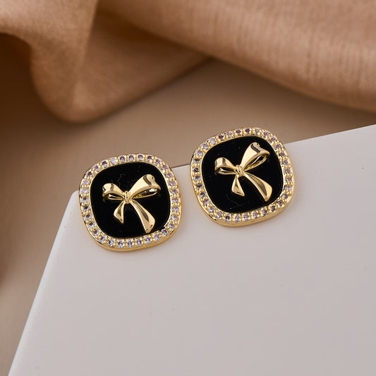 Chic Black Enamel Stud Earrings with Gold Bow Motif