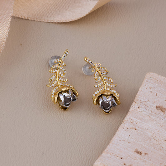 Elegant gold leaf earrings with a silver rose accent