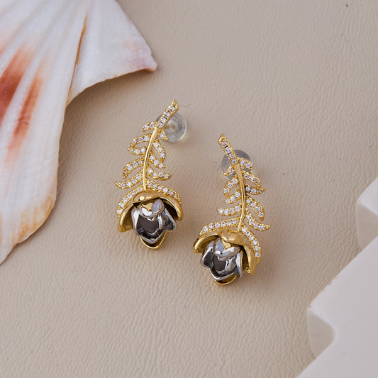 Elegant gold leaf earrings with a silver rose accent